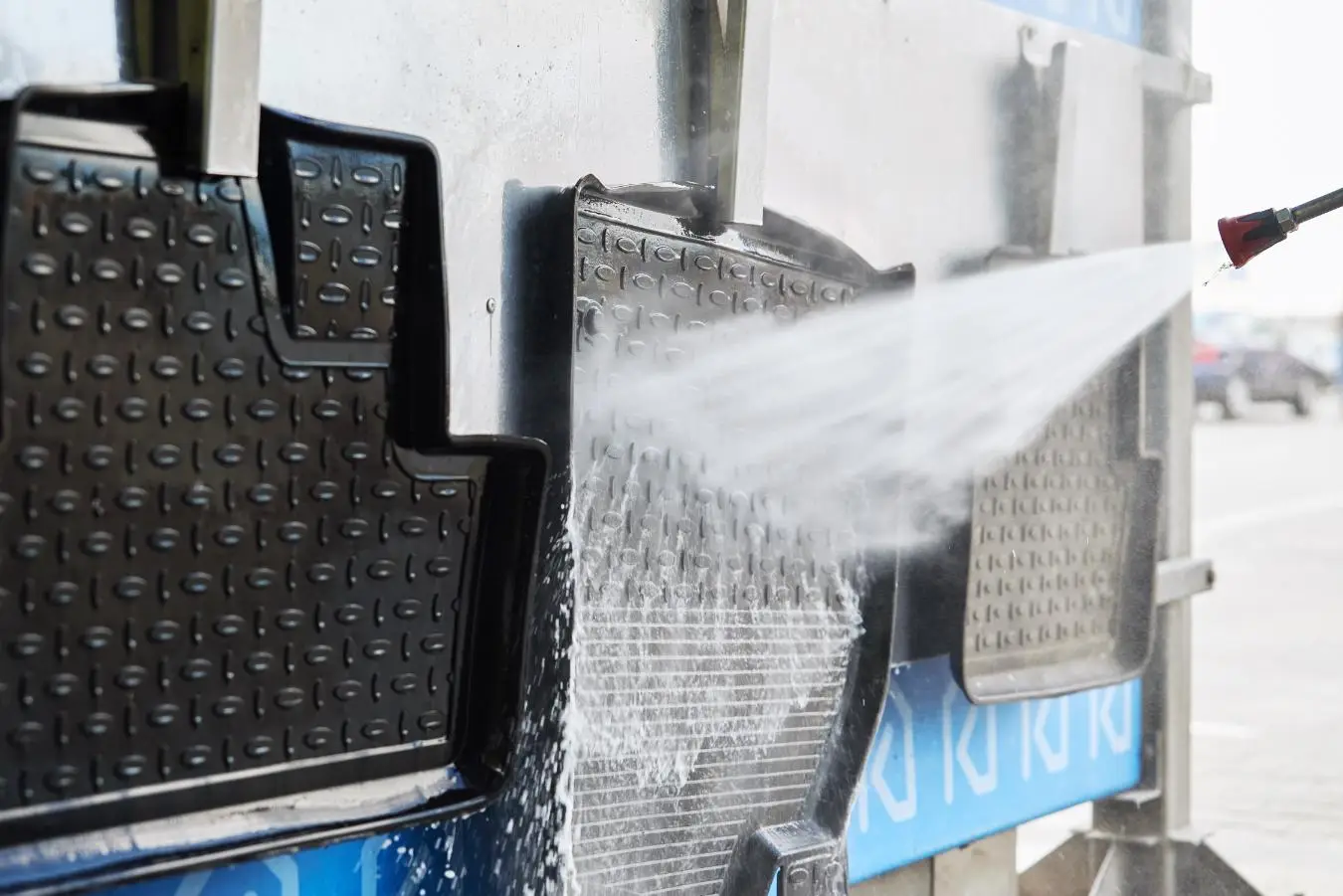 cleaning car mat with high pressure water at car w 2023 11 27 05 29 00 utc 1