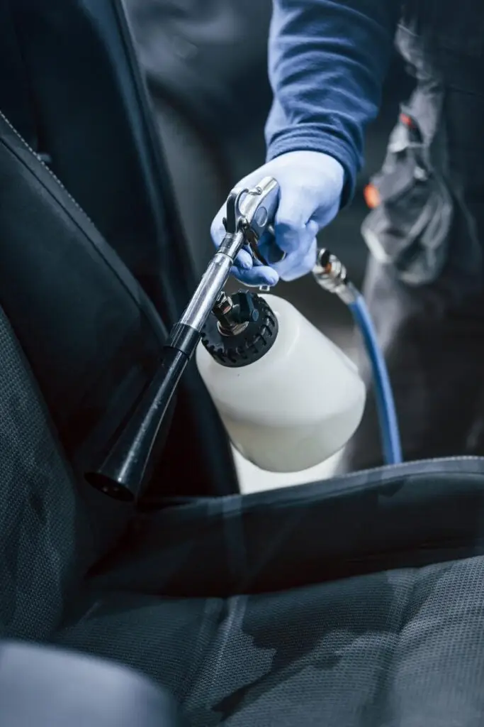 male worker in uniform cleaning new modern car co 2023 11 27 05 23 55 utc