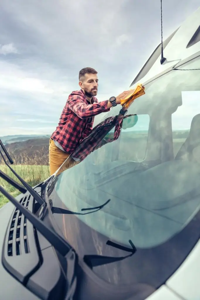 man cleaning camper van windshield outdoor 2023 11 27 05 27 40 utc 1